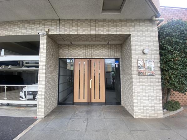 木製の両開きドアに縦型ガラスパネルがあり、上品で落ち着いた印象