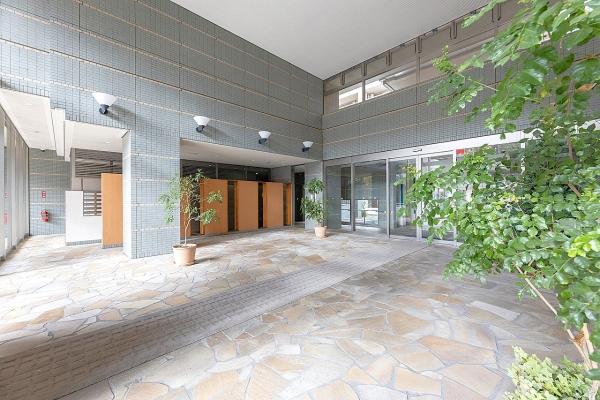 重厚感のある木目調の扉が目を引くマンションエントランス