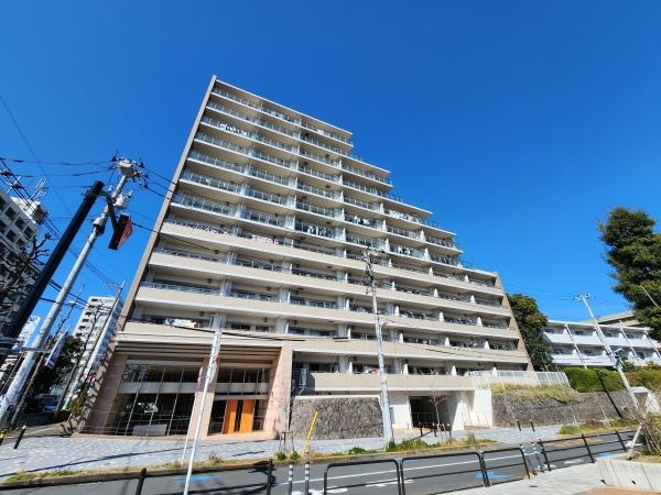 周辺の緑と調和したアースカラーのファサード