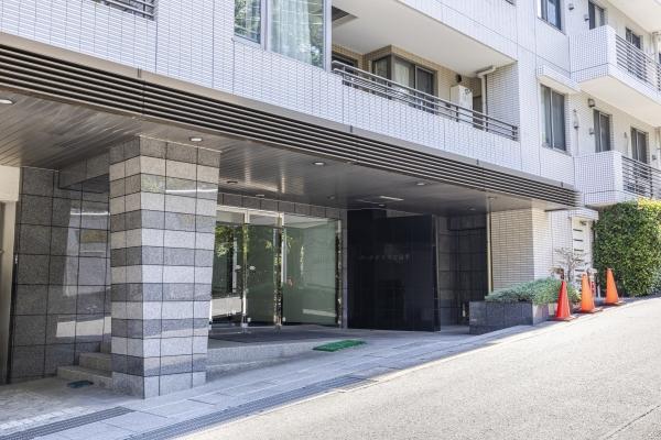 人車分離の安全設計。中央の御影石張りの柱が重厚感を演出するエントランス