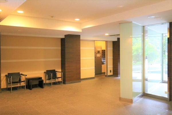 人車分離の安全設計。中央の御影石張りの柱が重厚感を演出するエントランス