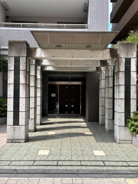 前面道路から距離を保ったアプローチ。御影石の門柱がアクセントになります。