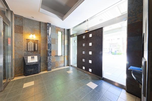 前面道路から距離を保ったアプローチ。御影石の門柱がアクセントになります。