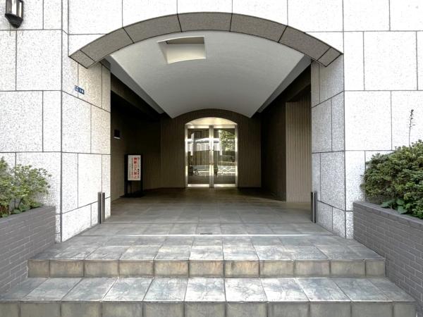 重厚感ある石張りアーチと奥行きのあるアプローチが、住まう方とゲストを上質に迎える格調高いエントランス