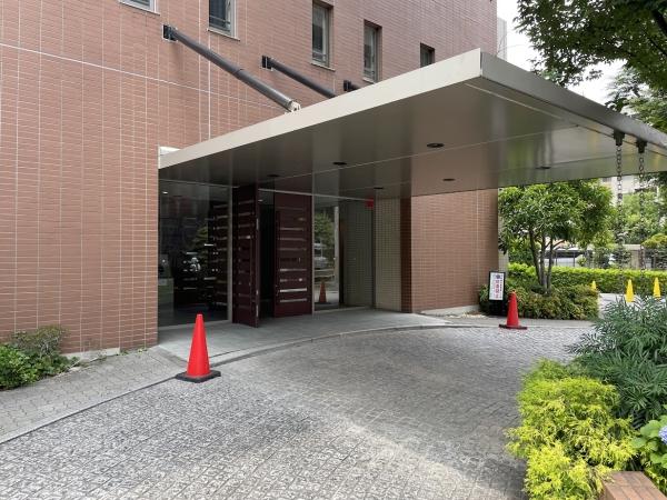 ゆったりと弧を描くアプローチをもった車寄せのあるマンションエントランス