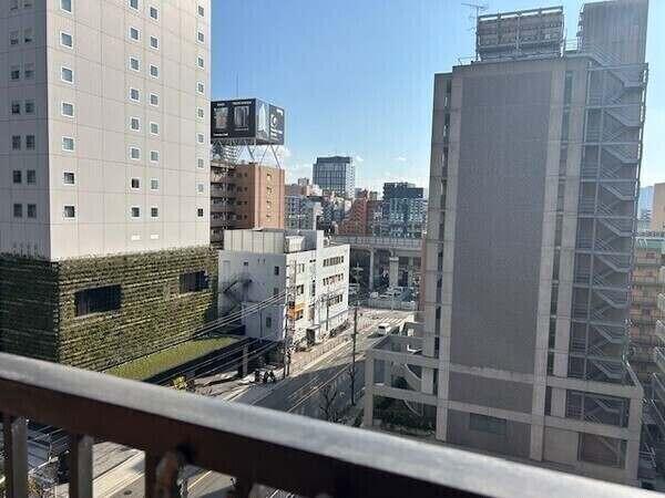 バルコニーからの眺望です。高層の建物が建ち並ぶ活気ある街並み。一部視界が抜け、開放感が感じられます。