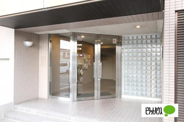 タイル貼りの落ち着いた外観と明るく開放感のあるエントランス