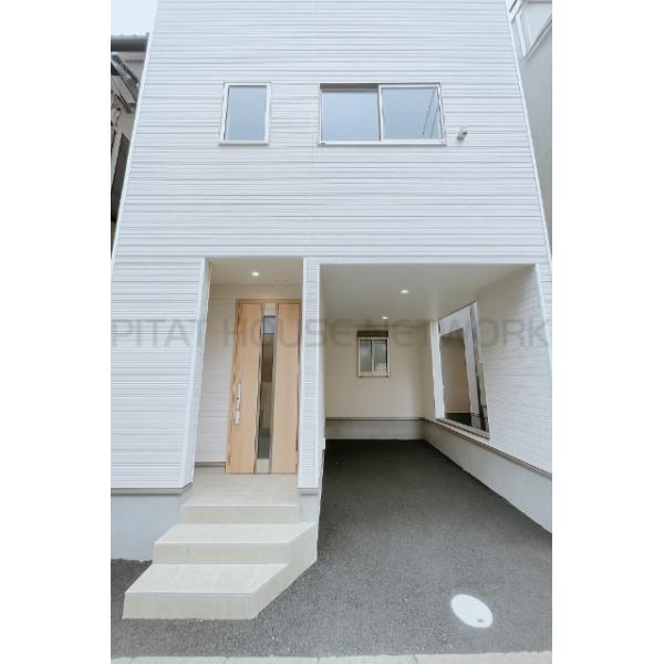 外観はシンプルな建売住宅ですが、駐車場は屋根付きで雨の日も安心です。玄関前にも屋根があり便利ですが、駐車場の間口は少し狭めです。建物を出てすぐが私道なので、歩行者や車の通行には注意が必要です。